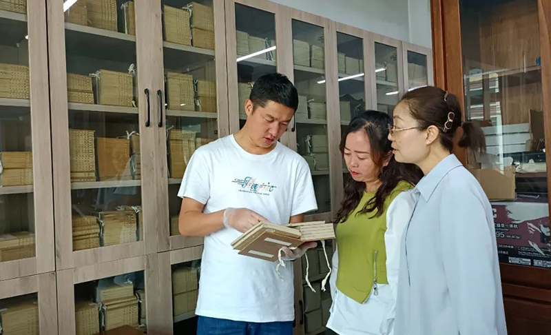 張旻（左）在大通縣圖書館了解、翻閱清代印制的經(jīng)史子集典籍