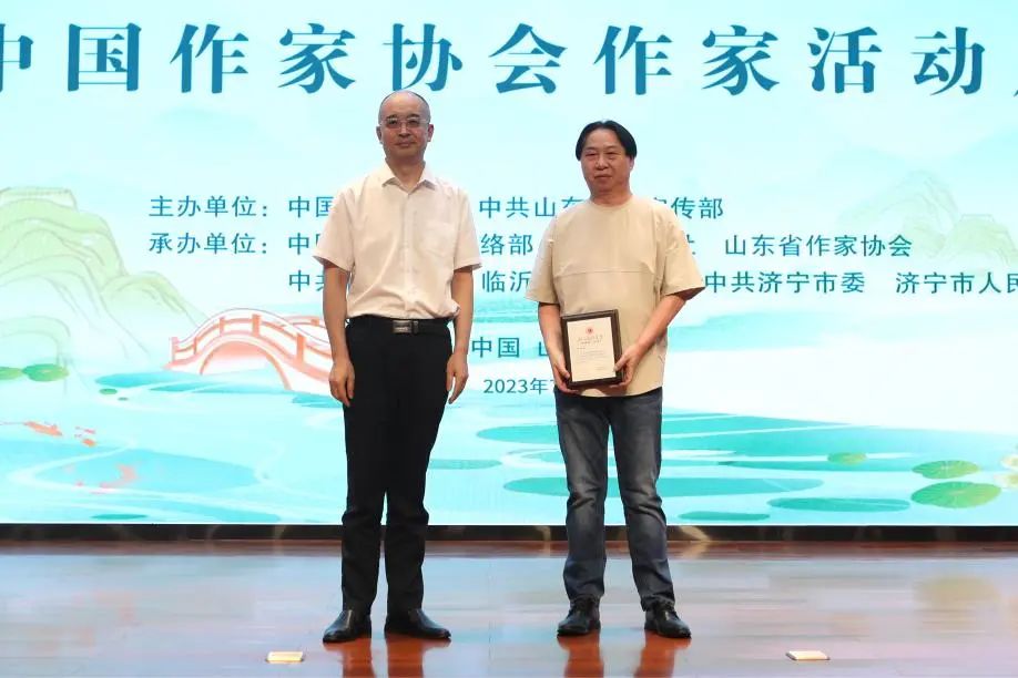 張宏森、吳義勤向參加此次“作家活動周”的中國作協(xié)會員逐一頒發(fā)專屬“入會紀念牌”