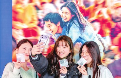 2月18日，觀眾在貴州省黔西市一家影院的電影海報前留影。 新華社發(fā)