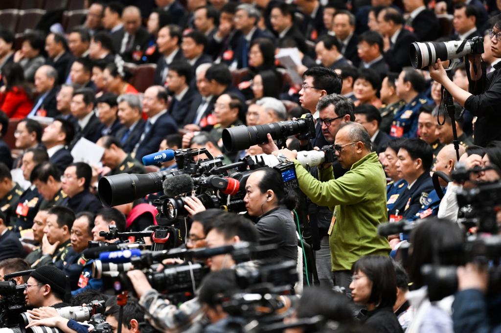 3月8日，十四屆全國人大二次會議在北京人民大會堂舉行第二次全體會議。這是記者在會議現(xiàn)場采訪。新華社記者 牟宇 攝