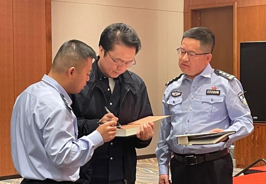 活動期間，陳彥（圖中）在給警營作家簽名。