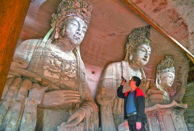 義務文保員在對重慶市大足區(qū)寶頂鎮(zhèn)香山社區(qū)的佛祖巖摩崖造像進行巡查。新華社記者 王全超攝