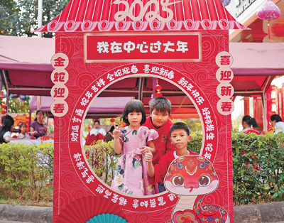 老撾民眾在“歡樂(lè)春節(jié)”廟會(huì)現(xiàn)場(chǎng)設(shè)立的新春祈福打卡點(diǎn)拍照。  坎帕頌攝